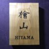 ヒノキ　はつり仕上げの表札　横12cm × 縦17cm (漢字２文字+ローマ字表記のタイプ)